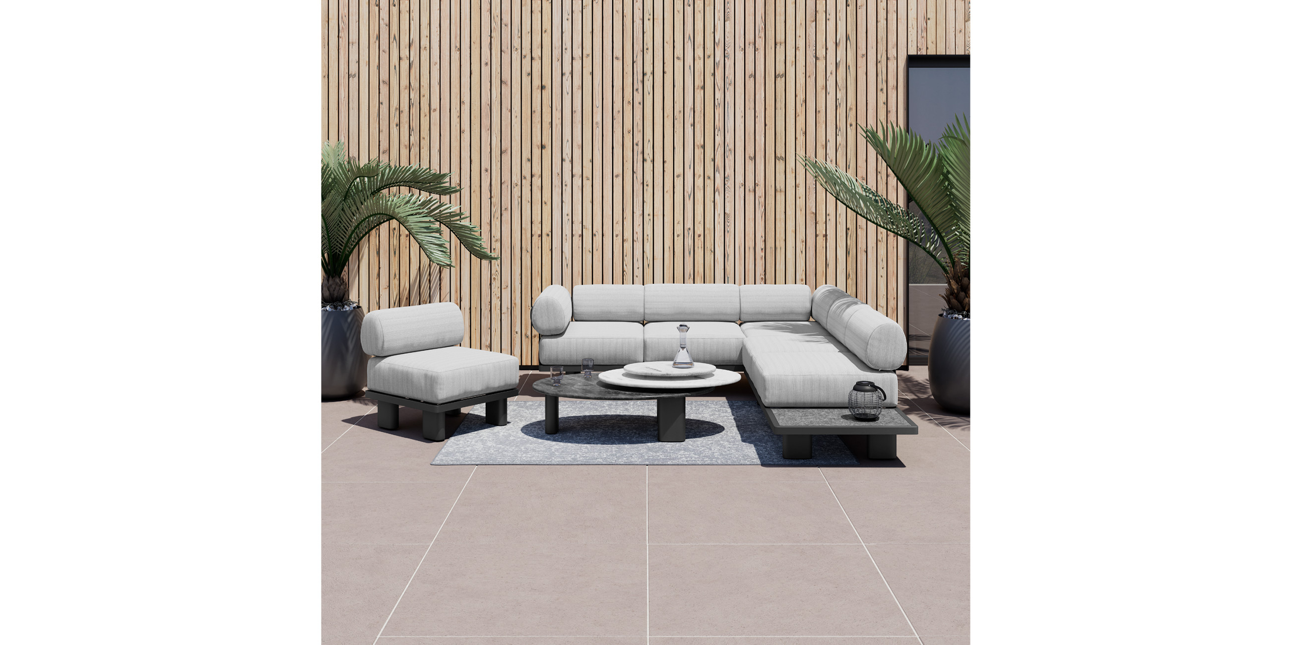 Dunkelgraue Loungegarnitur mit hellgrauen Kissen und rundem Beistelltisch 