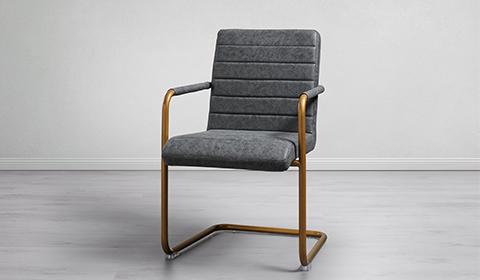 Gemütlicher Schwingstuhl mit dunkelgrauen Lederlook und einem Metallgestell in Goldfarbe von mömax.