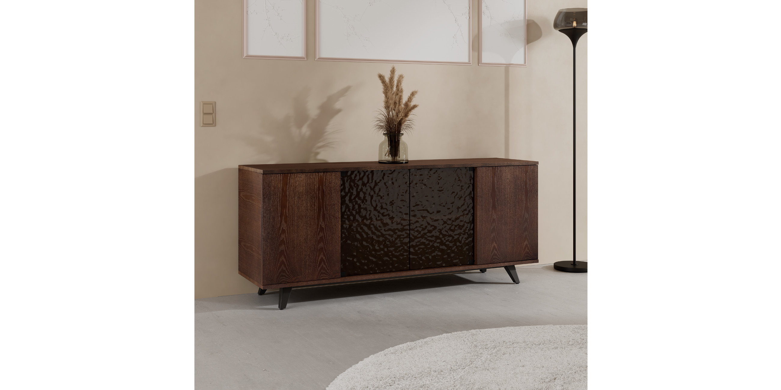 Sideboard aus Holz it Glasfront, schwarze Stehleuchte rechts daneben
