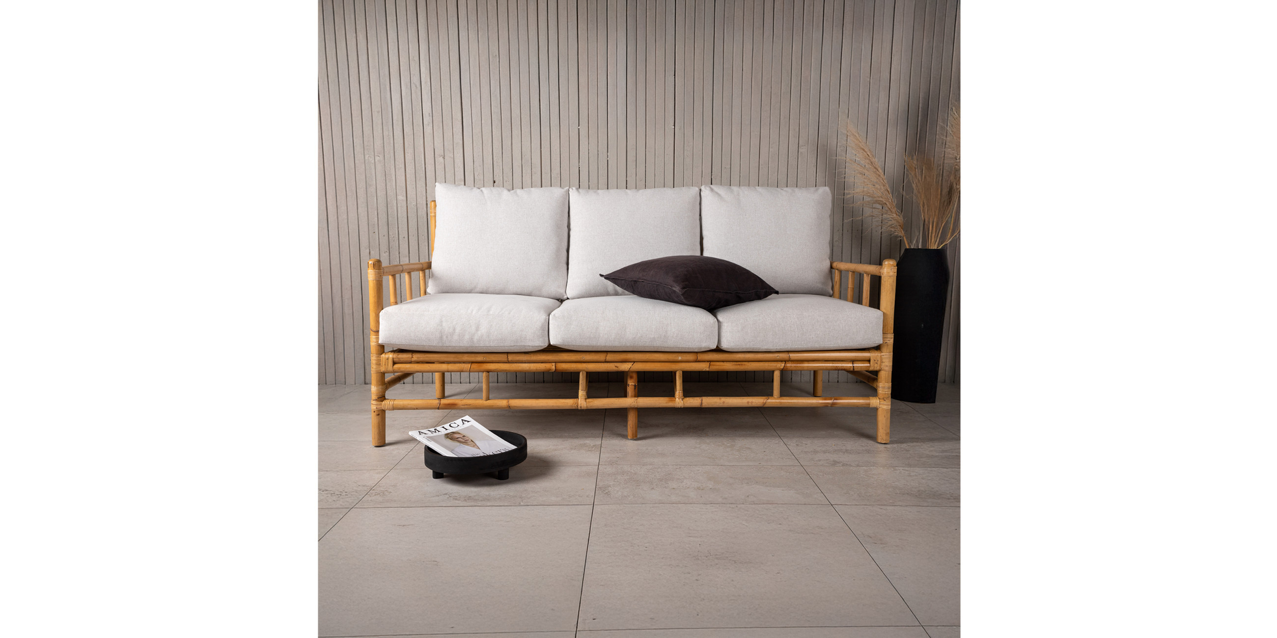 Rattan-Sofa mit hellgrauen Kissen