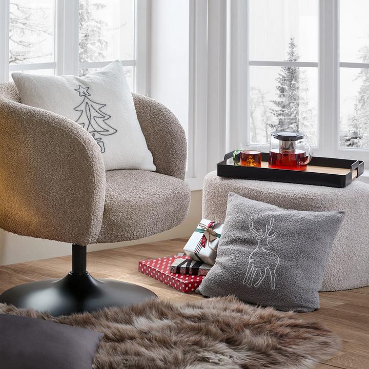 Relaxsessel mit hellen Weihnachtskissen und Teekanne