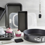 Auswahl an Backformen, einige Muffins und eine Abdeckung