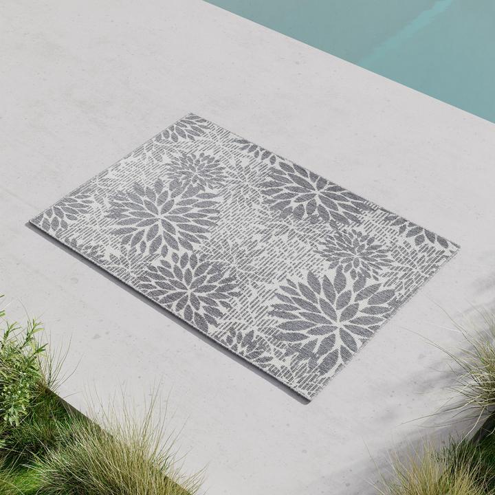 Grau gemusterter Outddoorteppich neben Pool