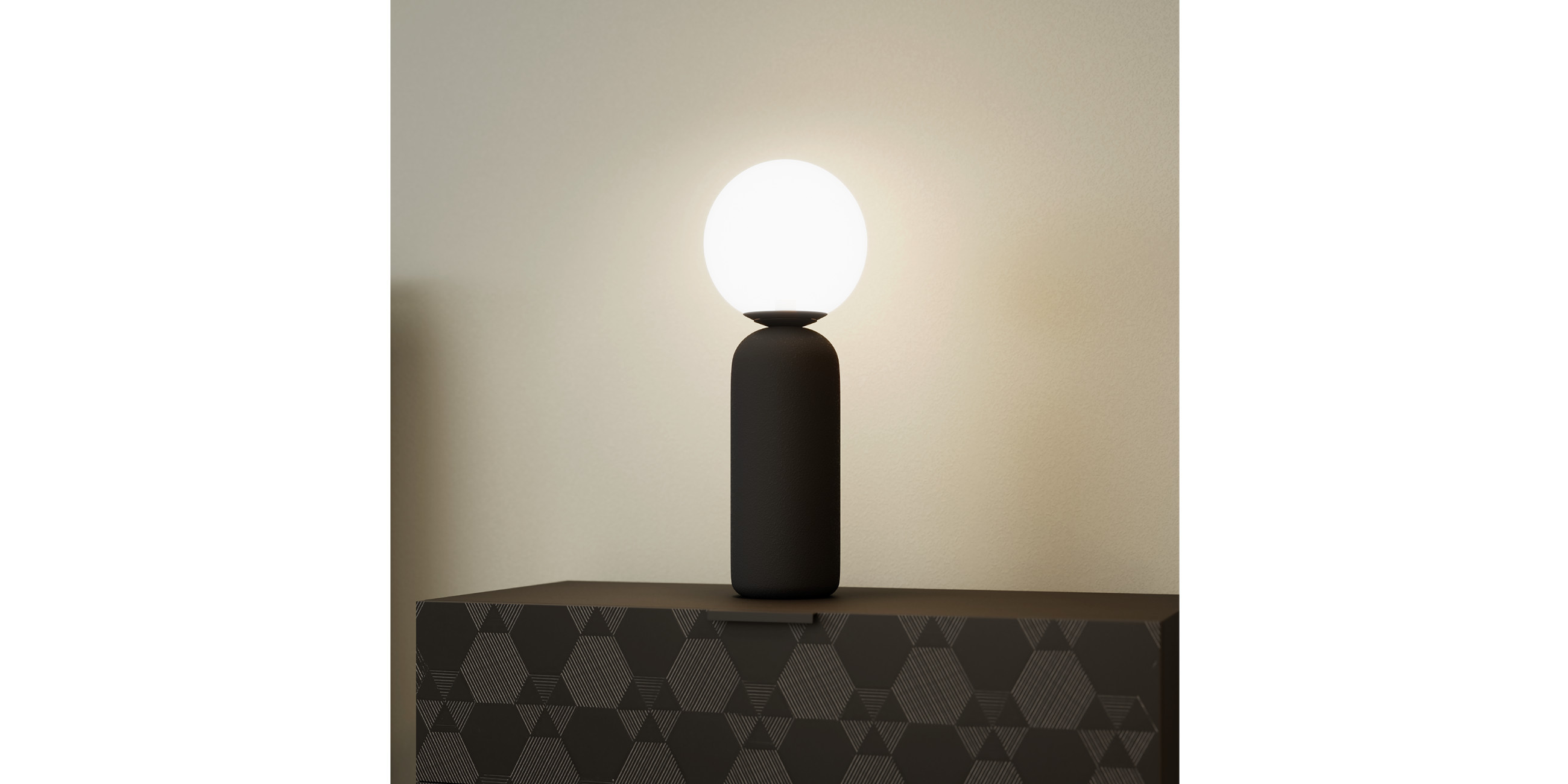 Schwarze Tischleuchte auf schwarzem Sideboard