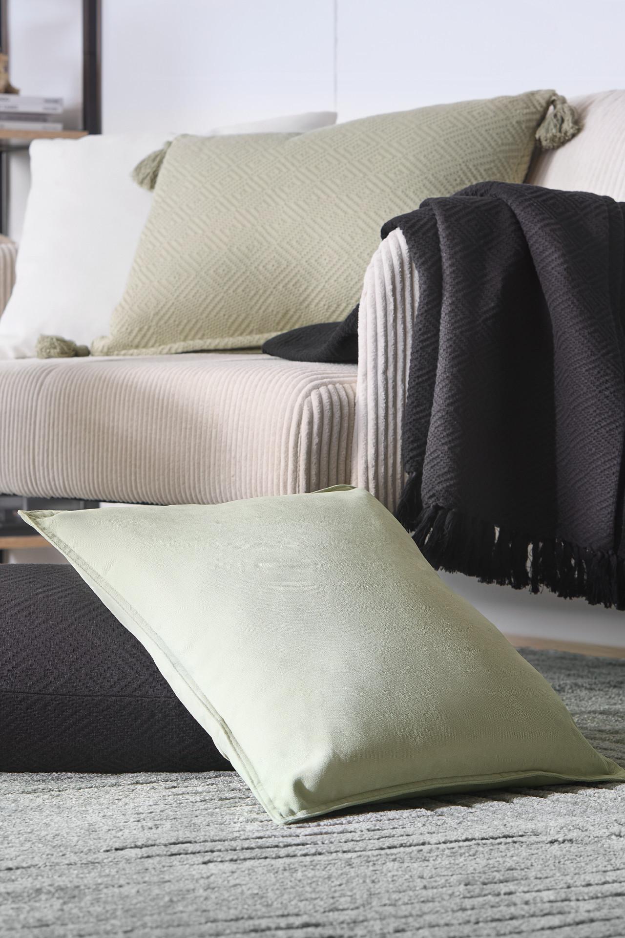 Grünes Kissen, schwarze Decke