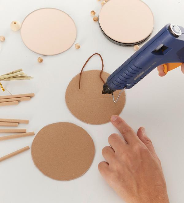 Pomiędzy dwa wycięte kółka dajemy kawałek sznurka na zawieszenie i sklejamy je