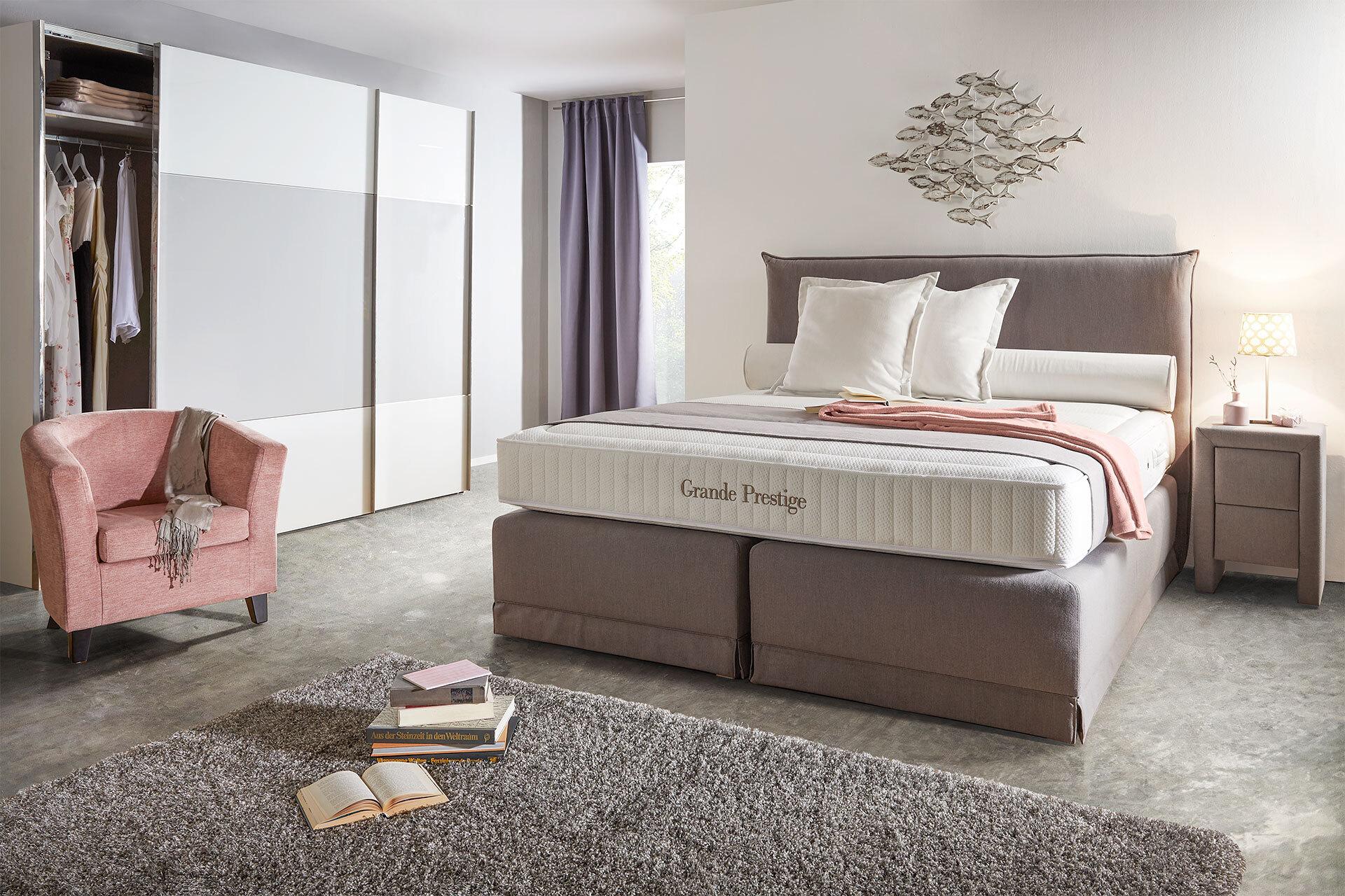 Graues Boxspringbett von moemax mit stabiler Federbox und Tonnentaschenfederkern-Matratze von moemax.