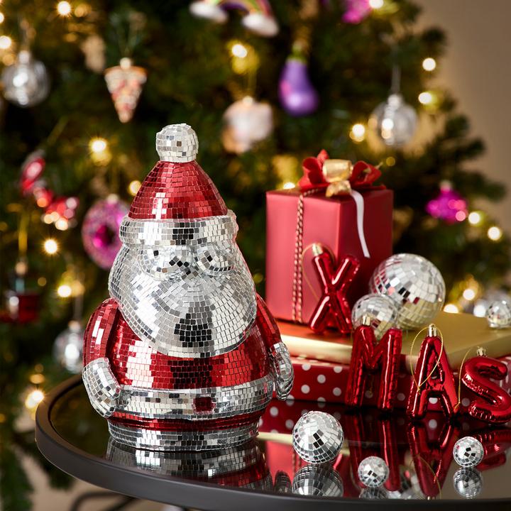 Disco-Weihnachtsmann auf Couchtisch, Christbaum im Hintergrund