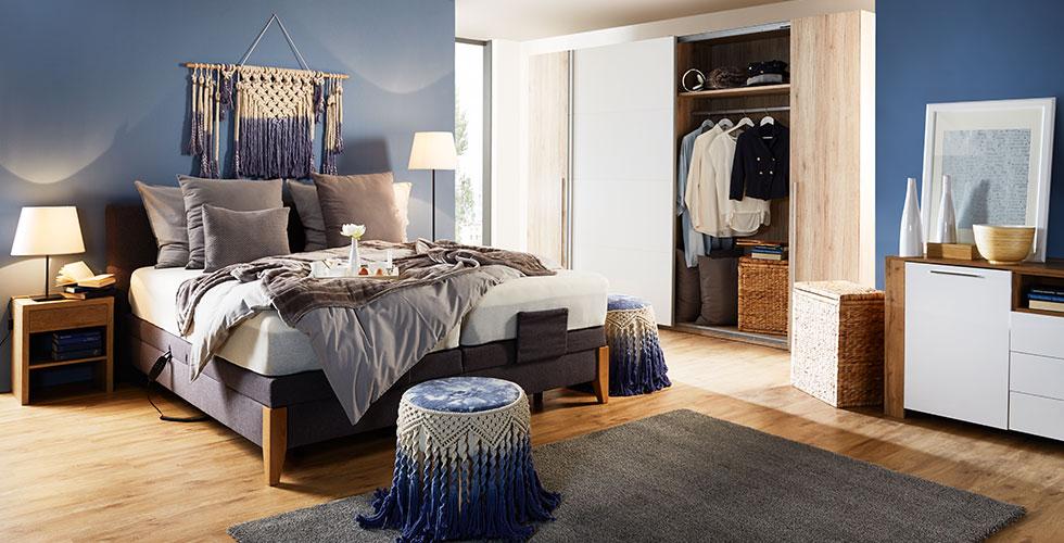 Großes Boxspringbett mit Echtholz-Elementen aus Eiche und grauen Stoffbezug von mömax.
