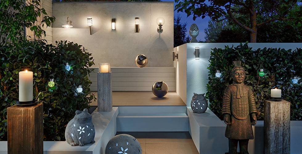 Terrasse mit Wandaußenleuchten in Stab- und Kugelform sowie Dekoleuchten in Tierform von mömax.