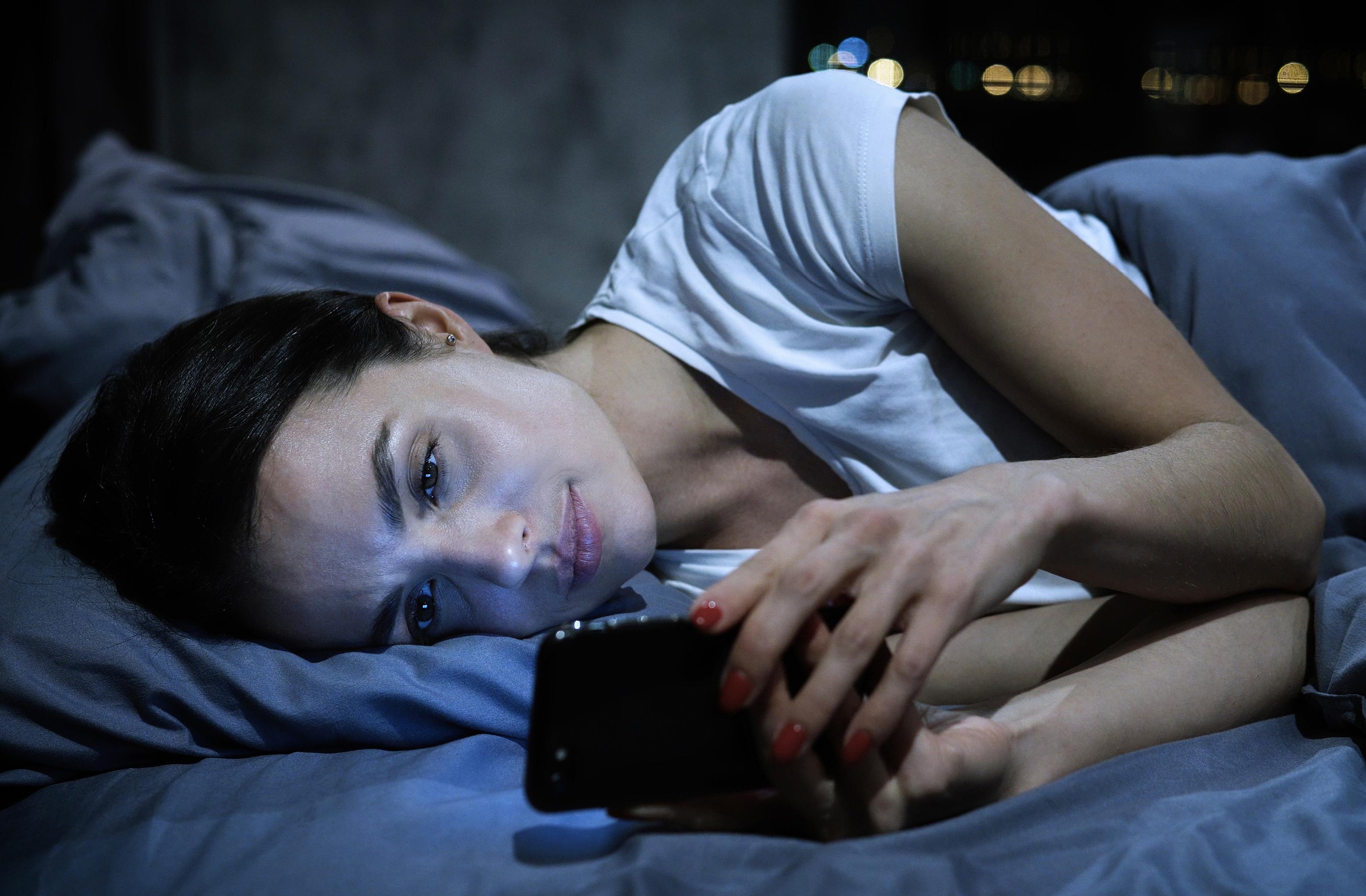 Kobieta w łóżku z telefonem