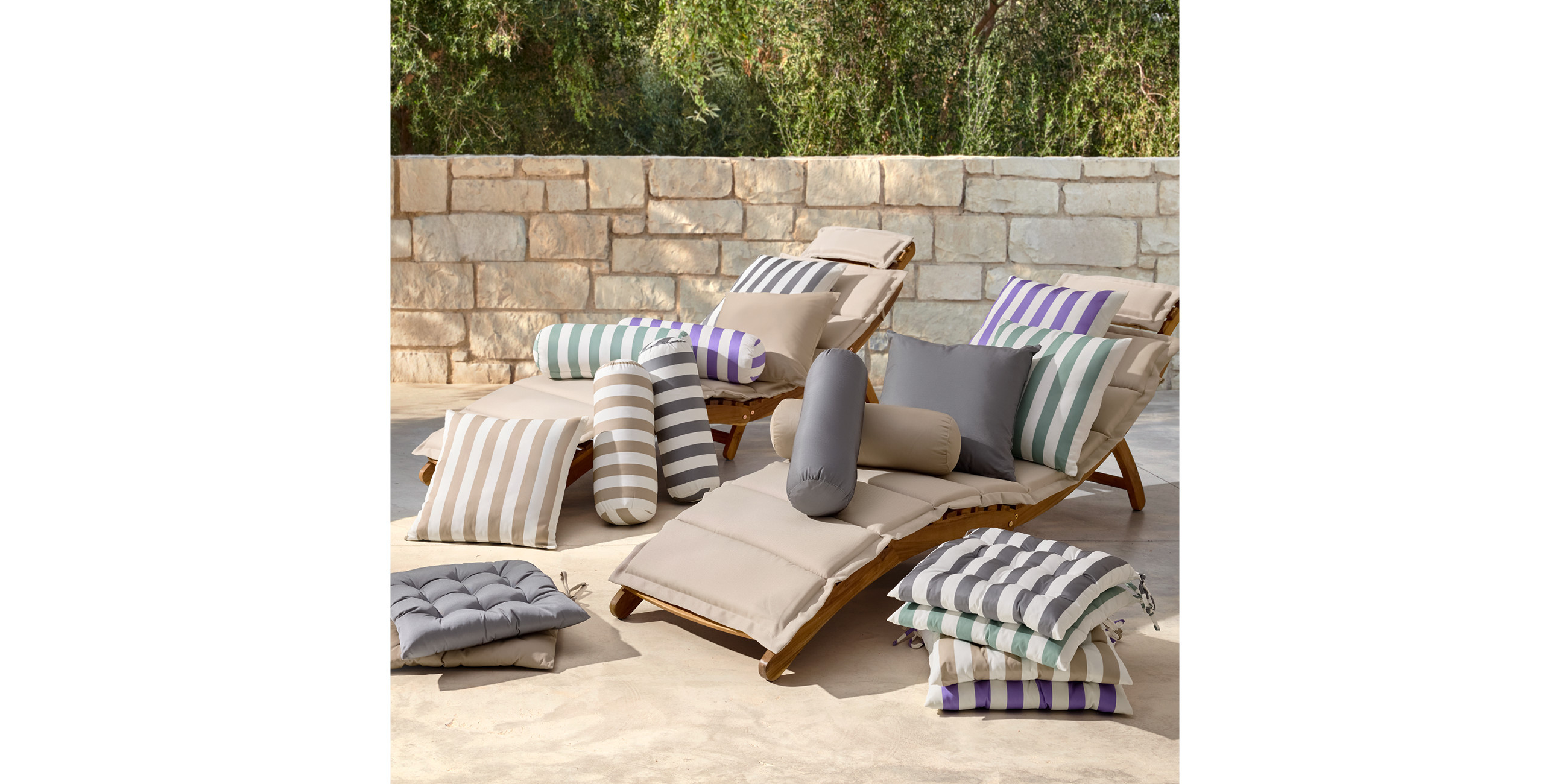 Verschiedenfärbige und gestreifte Outdoor-Kissen auf einer Gartenliege