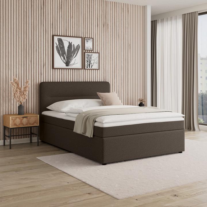 Dunkelbraunes Boxspringbett mit gepolstertem Kopfteil, naturfarbenes Nachtkästchen mit Metallbeinen