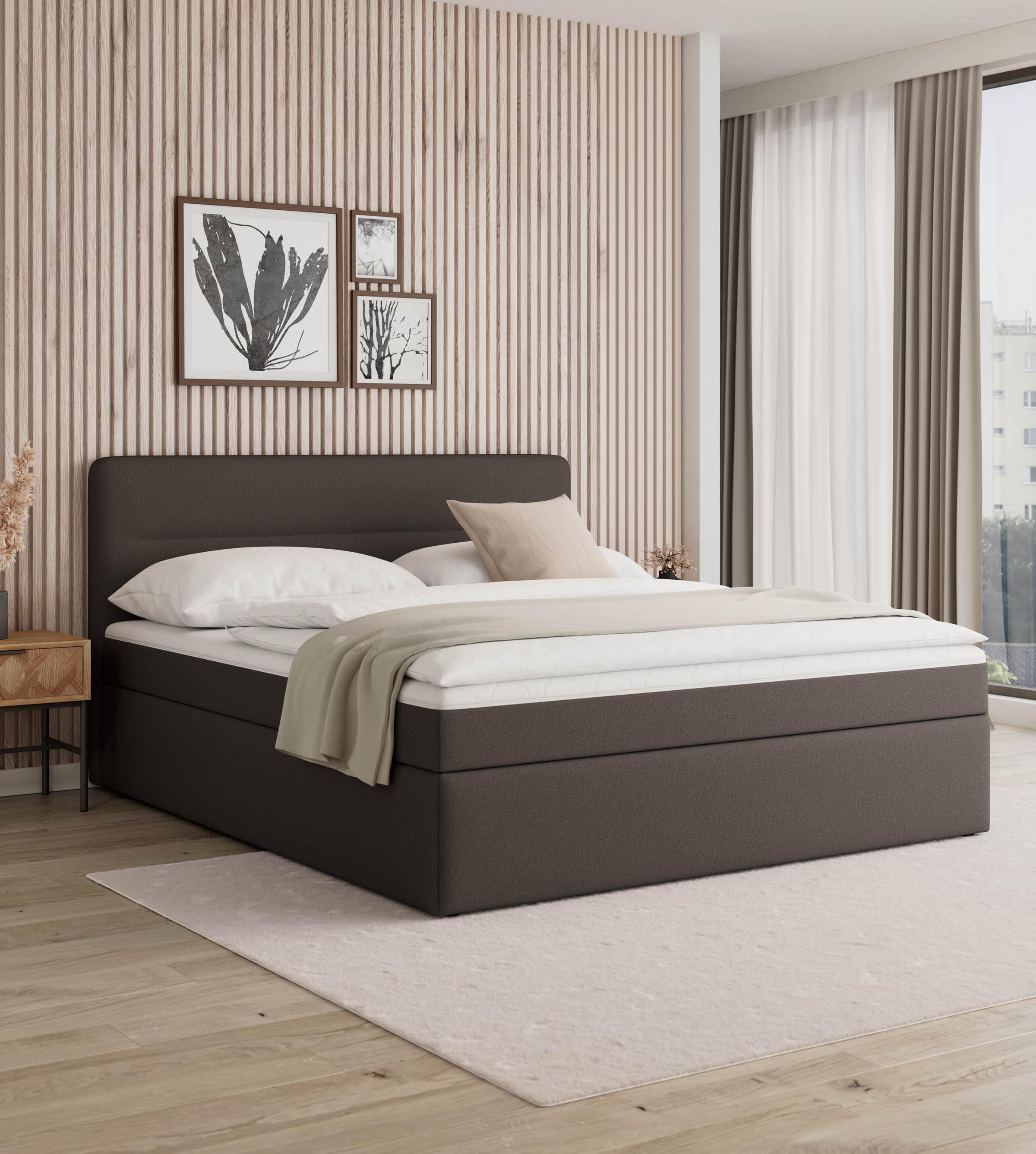 Dunkelbraunes Boxspringbett vor naturfarbenem Akustikpaneel