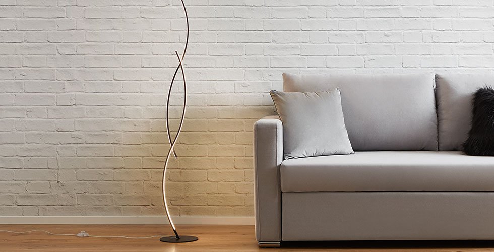 Moderne LED-Stehleuchten mit geschwungener LED-Lichtleiste und rundem Standfuß von mömax.