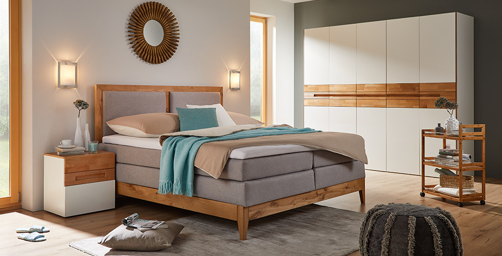 Boxspringbetten mit grauen Stoffbezug und Holzelementen von mömax.