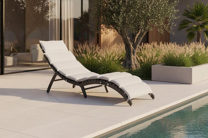 Helle Gartenliege mit schwarzem Gestell vor Pool