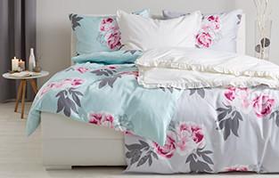 Doppelbett und Bettwäsche mit Blumenmuster von mömax.