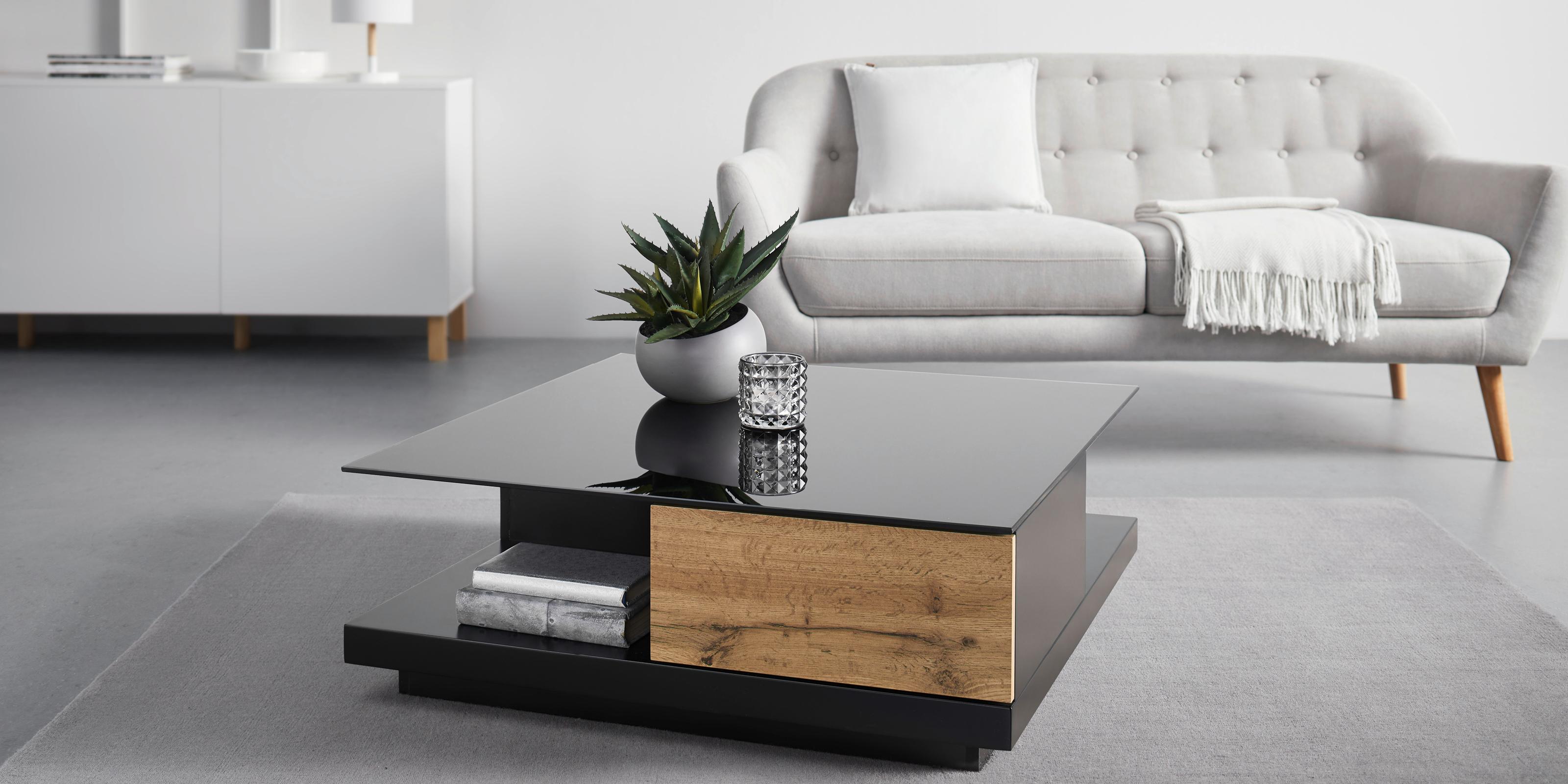 Szara sofa i czarny stolik kawowy