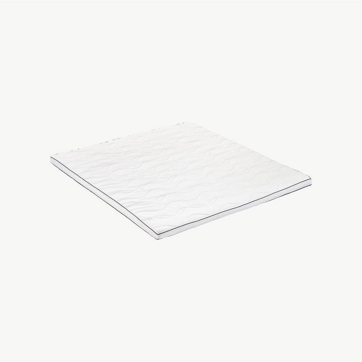 Weißer Matratzen-Topper vor hellem Hintergrund