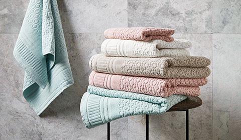 Gestapelte Handtücher in Creme, Taupe, Rosa und Mintgrün von mömax.
