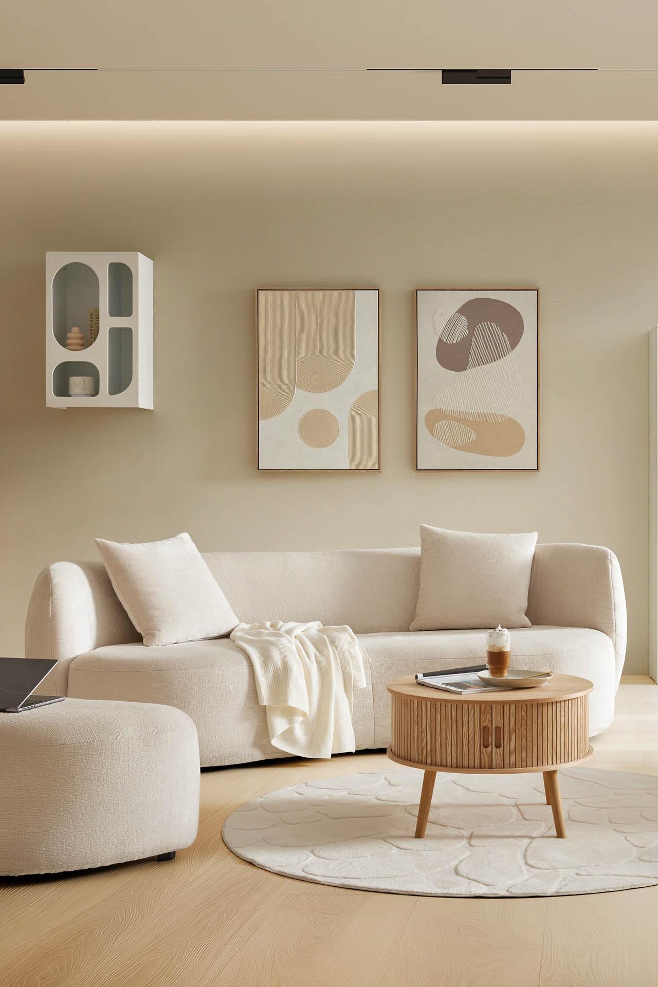 Beiges Sofa mit zwei Kissen, runder Couchtisch aus Holz