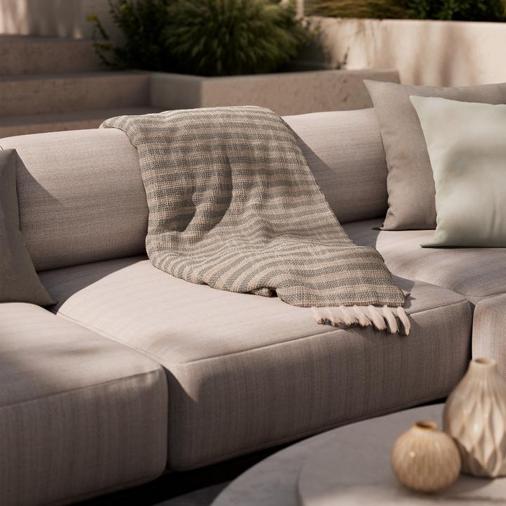 Braun-weiß gestreifte Decke auf Loungegarnitur