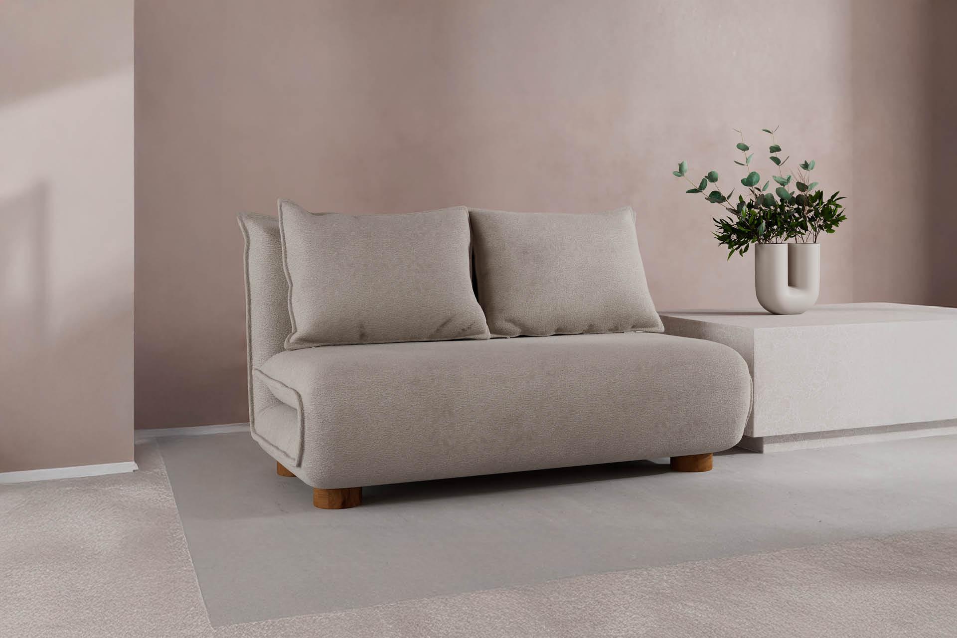 Beiges Schlafsofa mit weißem Couchtisch daneben vor rosa Wand