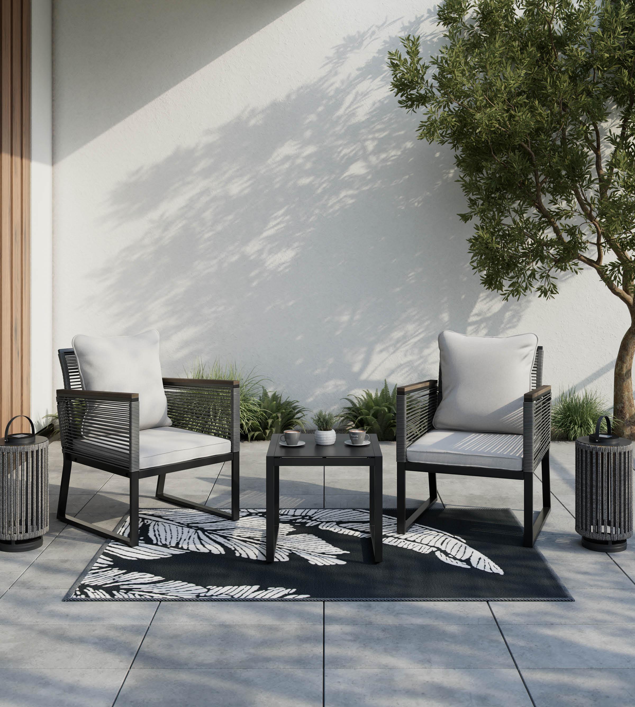 Gartensessel-Set dunkelgrau mit hellgrauen Kissen und Auflagen, schwarzer Beistelltisch und schwarz-weißer Outdoorteppich